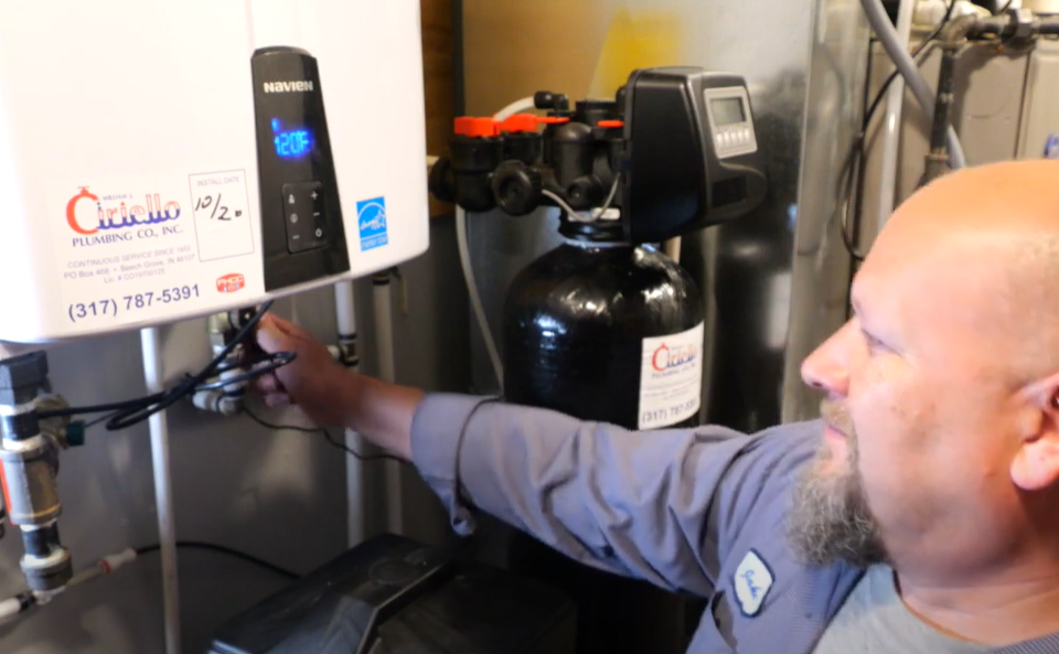 plumber flushing a tankless water heater