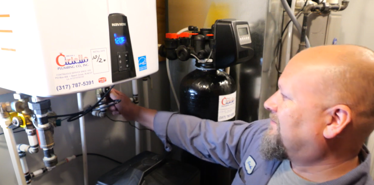 plumber flushing a tankless water heater
