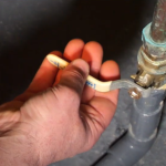man using a water shut-off valve