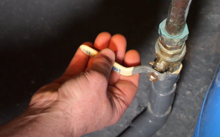 man using a water shut-off valve