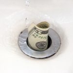 $5 bill going down the drain