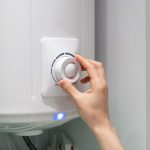 Woman adjusting water heater temperature