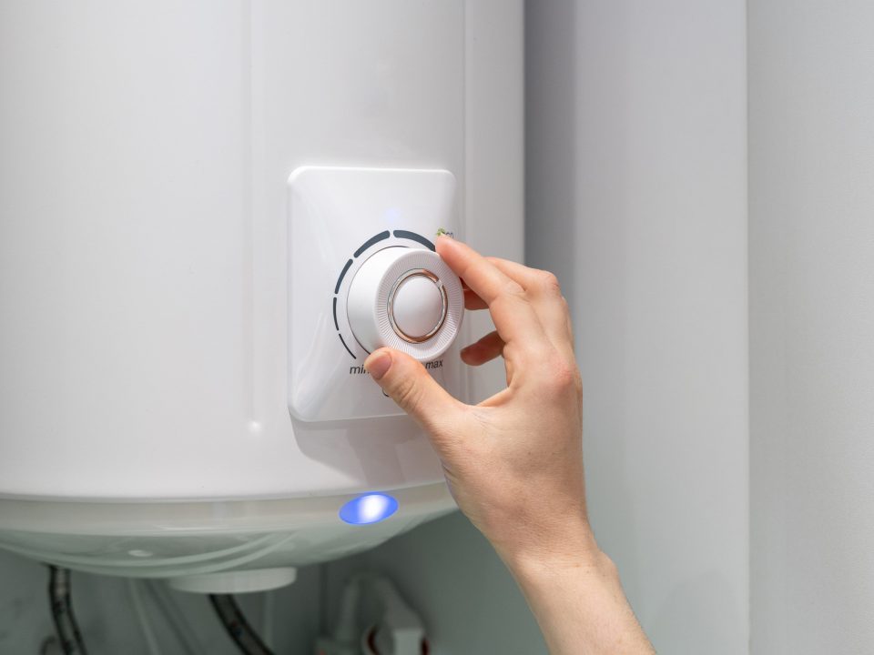 Woman adjusting water heater temperature