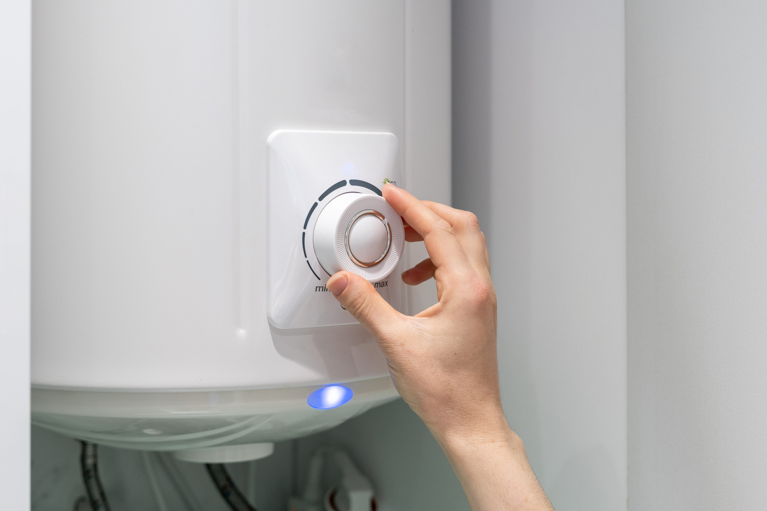 Woman adjusting water heater temperature